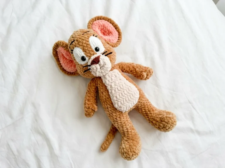 Brown plush Jerry mouse toy on white bedding for this tom and jerry crochet pattern free.
