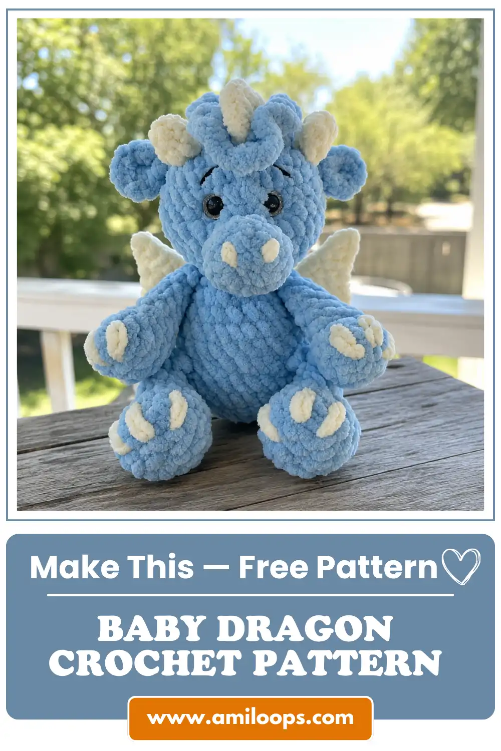 Blue chenille toy from a baby dragon crochet pattern free with cream claws sitting on an outdoor wooden slatted deck.