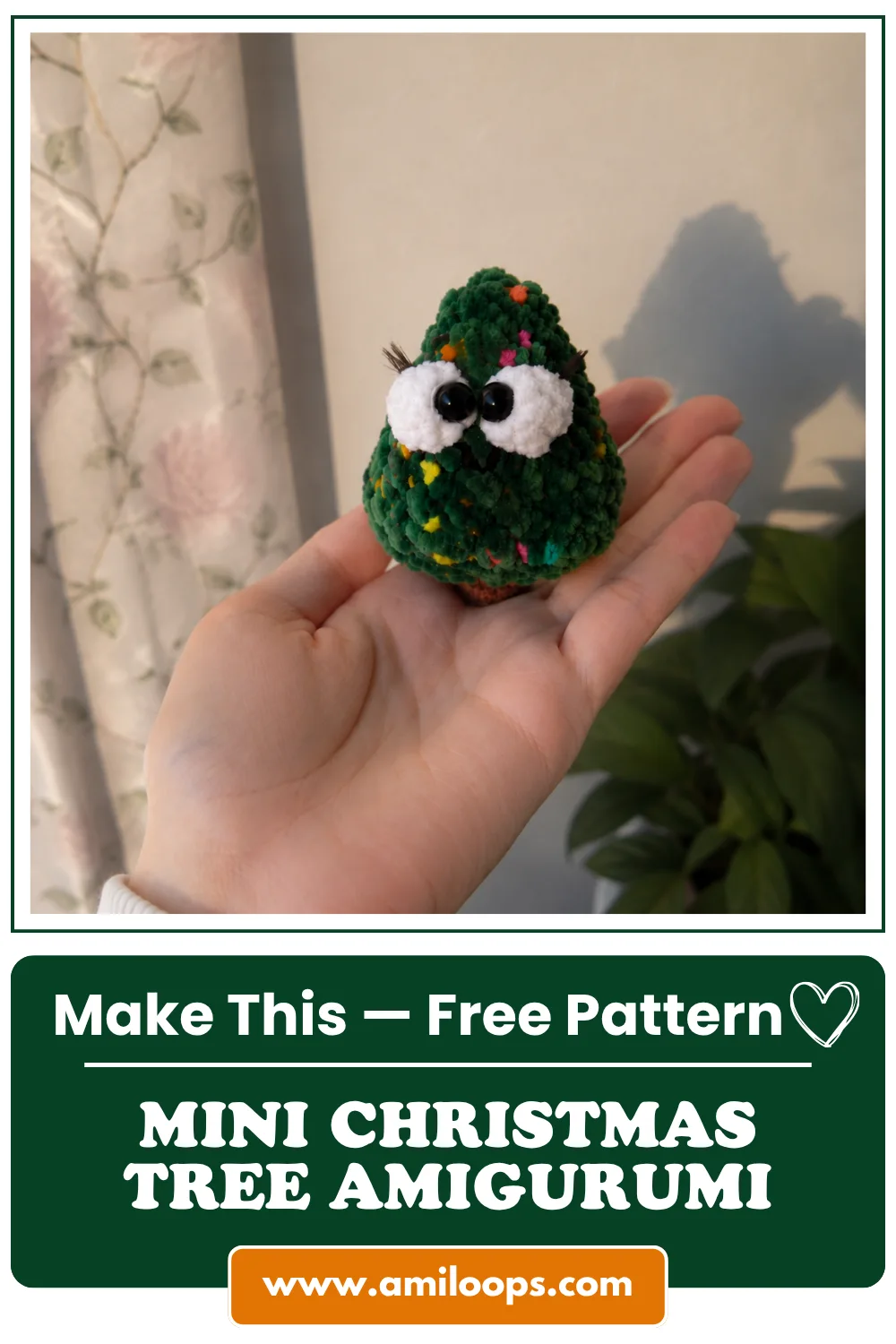 Close-up of the tiny green fluffy amigurumi Christmas tree with eyelashes held by a hand on AmiLoops.com
