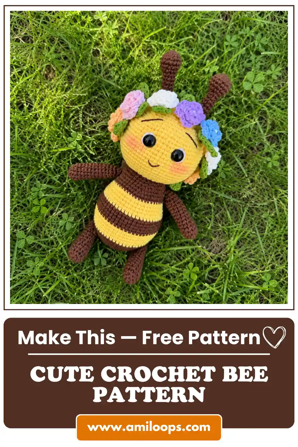 Amigurumi crochet bee pattern toy made with yellow and brown yarn and a pastel flower crown, lying flat on green grass.