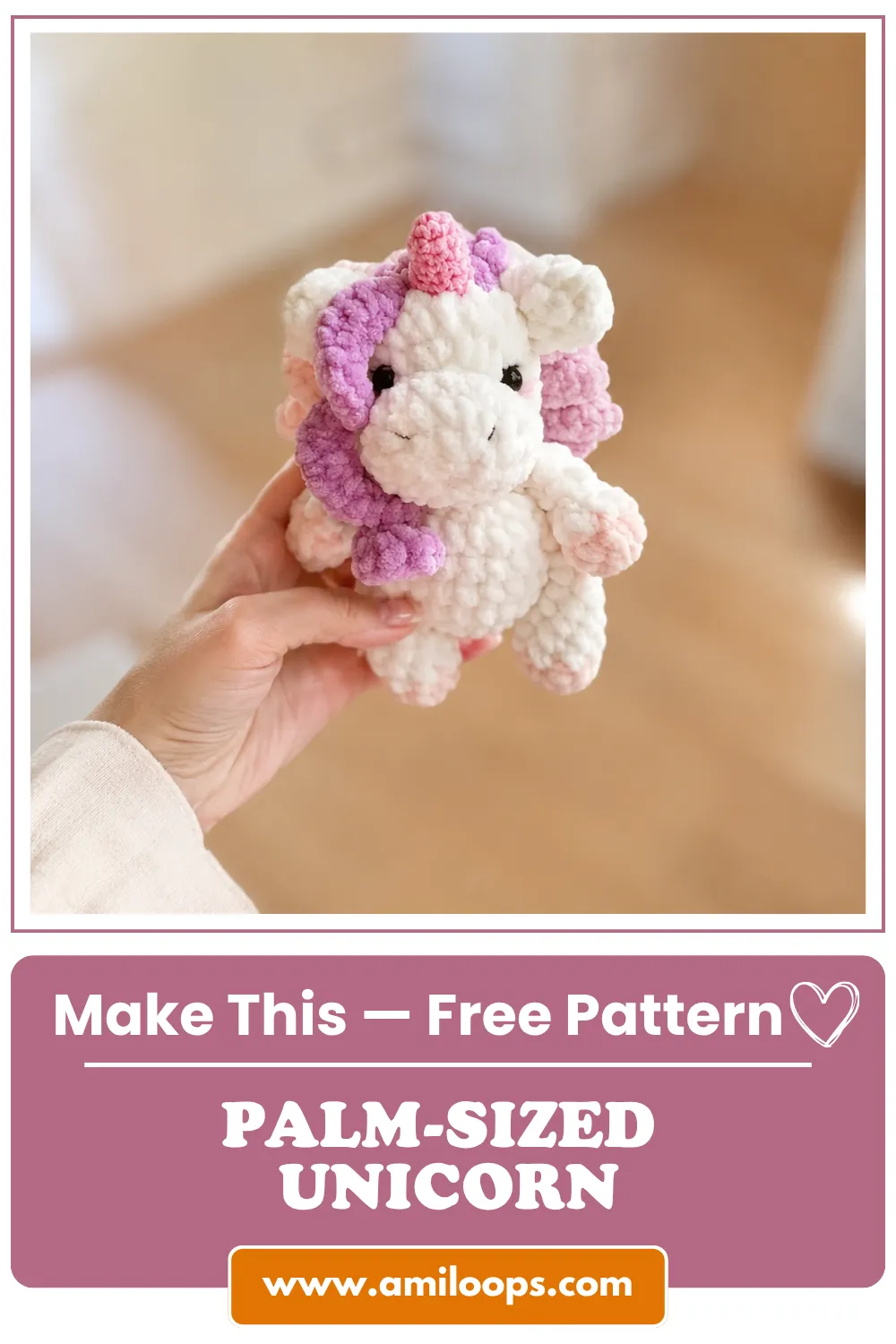 Hand holding a white chunky yarn toy with purple mane from our mini unicorn crochet pattern free, blurred background.