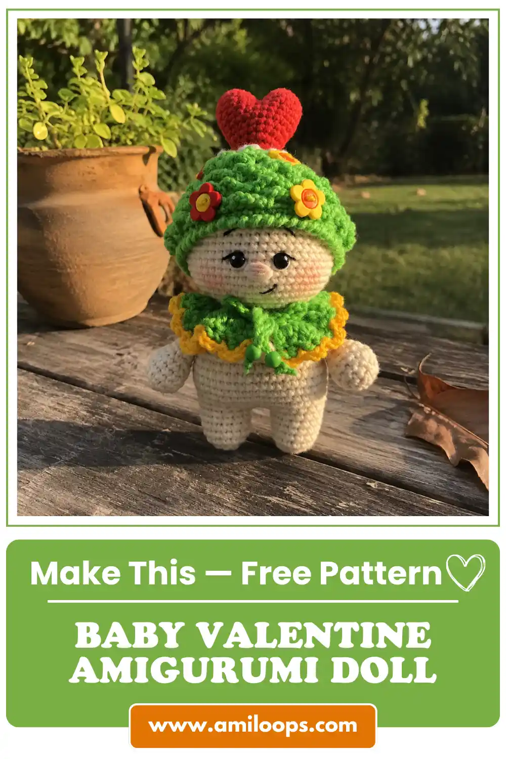 White yarn doll with green hat and red heart on an outdoor wooden table. Baby valentine amigurumi free pattern.