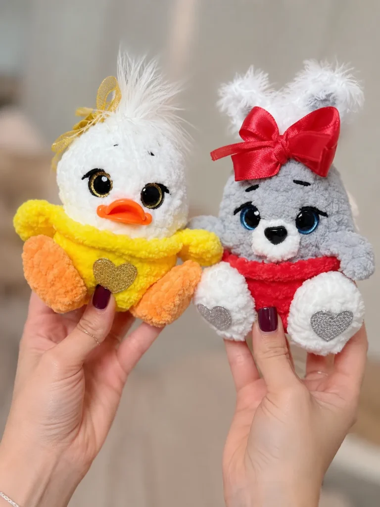 A close-up of hands holding finished plush toys made from the crochet bunny and duck easter eggs free pattern.