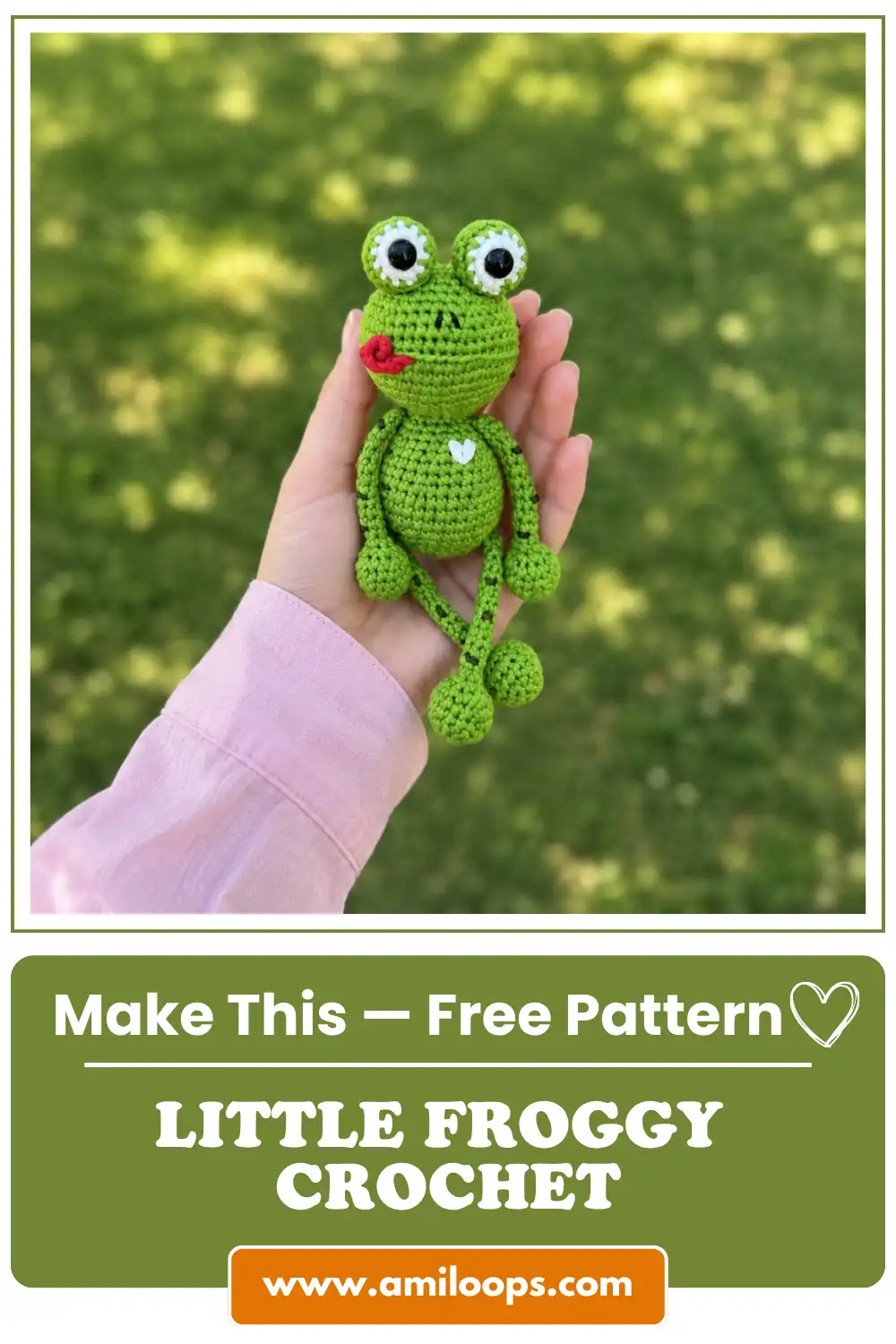 Hand holding a green yarn kvaka the little froggy free crochet pattern outdoors against a blurred grass background.