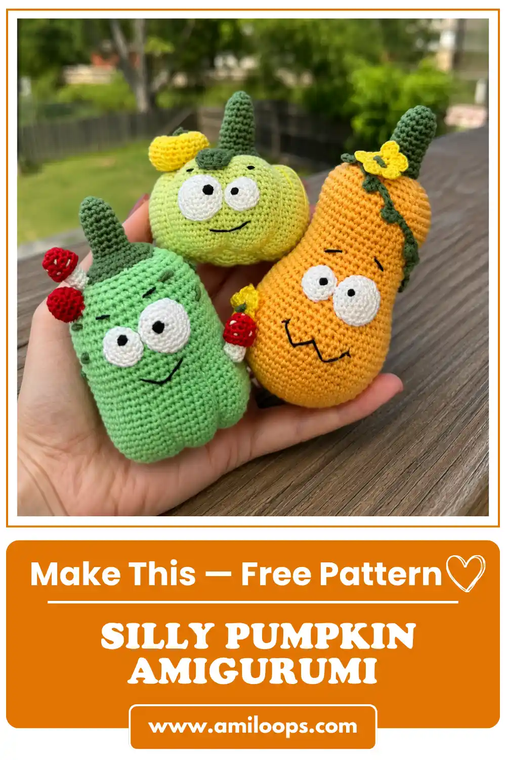 A hand holds three yarn toys from the silly pumpkin amigurumi pattern outdoors over a wooden deck with a blurred background.