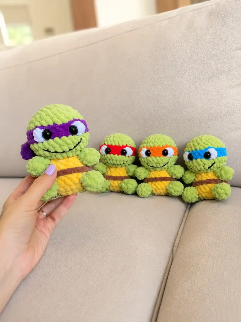 Front view of a purple-masked toy from a teenage mutant ninja turtles amigurumi free pattern held near three other toys.