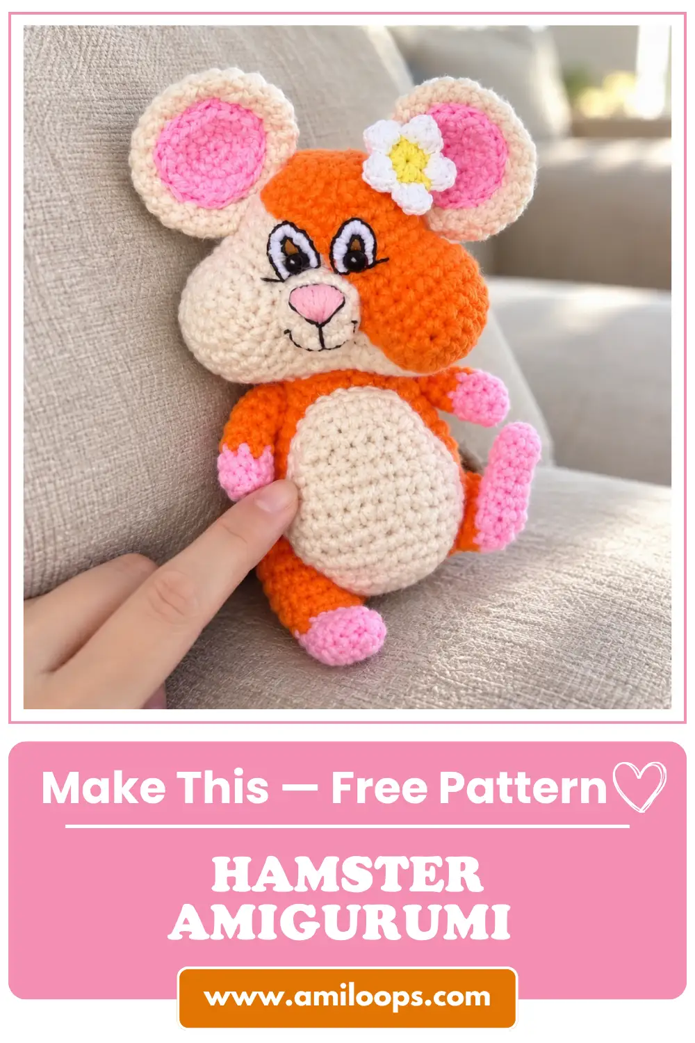 Orange and cream yarn toy from a hamster amigurumi free pattern sitting on a beige couch, with a finger touching its belly.