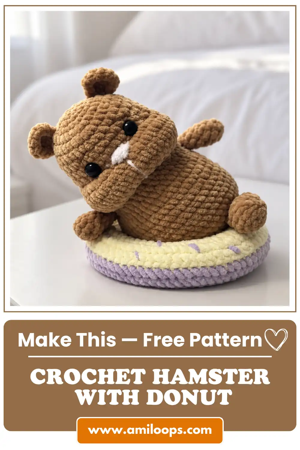 Brown plush crochet hamster with donut featuring yellow frosting and purple sprinkles, sitting on a white bedroom table.