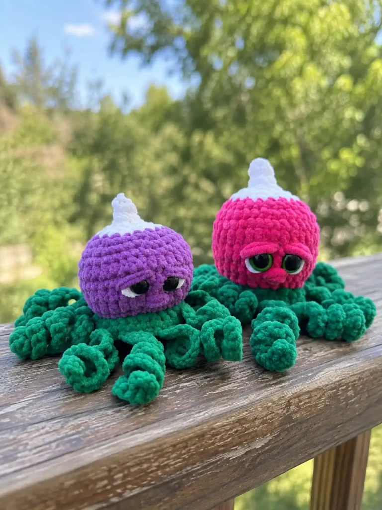 Purple and pink radish octopus crochet pattern toys with green tentacles sitting on a wooden railing outdoors.
