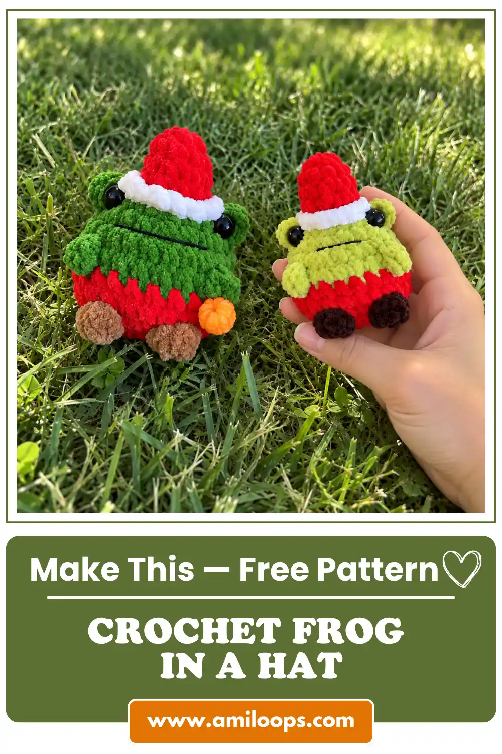 Two fuzzy crochet frogs in a hat sitting on green grass outdoors in the sunlight
