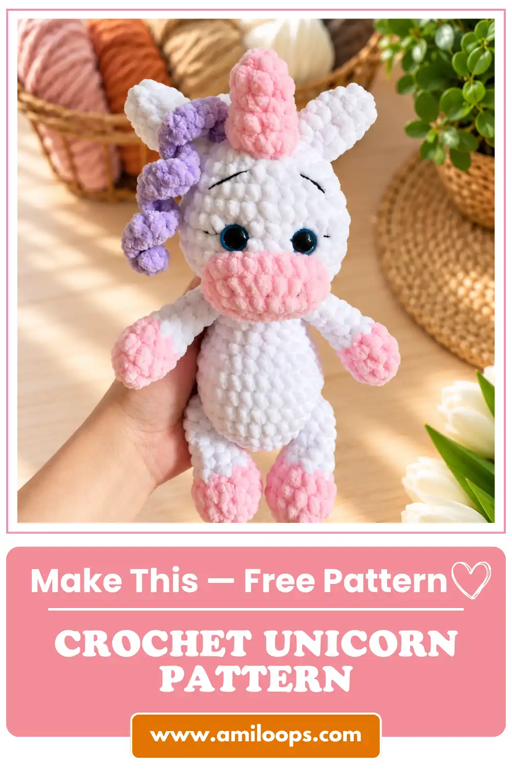 Close-up of a plush crochet unicorn with pink and purple curly mane held up against a basket of yarn.